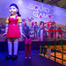 Squidgame Spielfeld neben Mörderpuppe Younghee vor Posterleinwand der Koreanischen Netflix Show