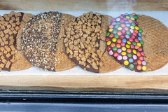 Stroopwafels, thin and round waffle cookie with chocolate and different toppings in a popular store in Amsterdam, Netherlands