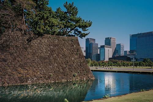tokyo - imperial palace, stone bridge, trees, green, blue sky,  moats and massive stone walls in the