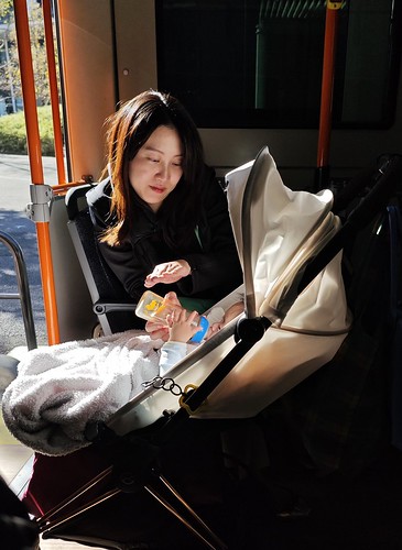 A mother looking at her milk drinking son in the bus in Tokyo..