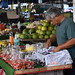 DSC_5112: a man standing in front of a fruit stand