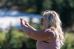 Blonde tourist woman takes a photo along the Tipsoo Lake trail in summer in Mt. Rainier National Park