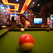 DSC_1200: a woman is playing pool in a bar