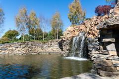 One of the many beautiful waterfalls going into a pond at Mayfield Garden and includes a cave