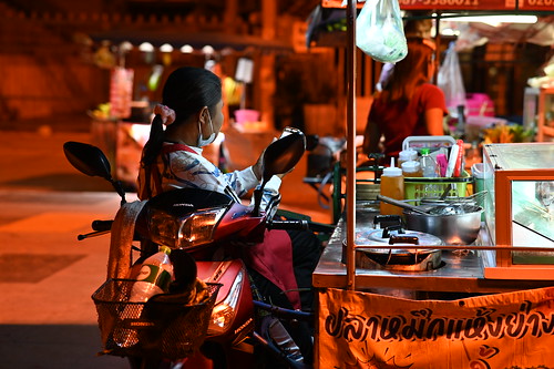 DSC_1554: a woman sitting on a motorcycle at a food stand