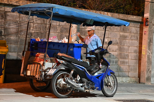 DSC_1563: a man standing next to a blue motorcycle