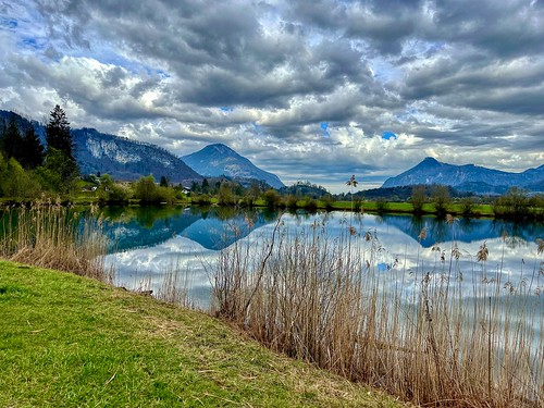 Lake Kreutsee with reflections under a cloudy sky near Kiefersfelden in Bavaria, Germany