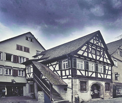 Est. 1511: Fachwerkhaus mit Außen Treppe. Das Haus links daneben bietet einen öffentlichen Durchgang zum Nonnenhaus Areal. Nonnenhaus ist heute Parkhaus und Einkaufszentrum. Marktplatz für Obst und beliebt bei Straßen-Musiker