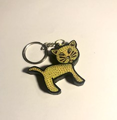 A stylized dotted feline kitty mitten Cat kitten of cute DIY-culture a custom very collectable fake animal connected by a chain to a ring for practical use ( Danny Hennesy art 2024 ) kunst gatto katt gato katze kat