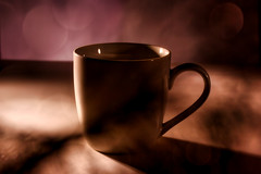 Coffee cup with handle on table with interesting shadows and light