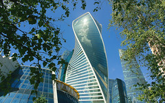 Modern architecture and nature of Russia. View through the trees to the Evolution tower (246 metres high) of the Moscow International Business Center (MIBC-“Moscow City” ), Presnenskaya embankment, Presnensky district.