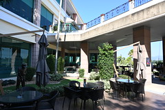 DSC_6900: a patio with tables and chairs and an umbrella