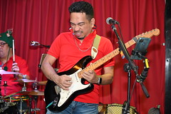 DSC_7317: a man playing a guitar in front of a microphone