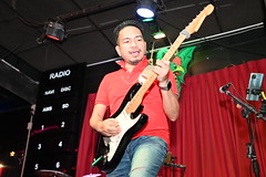 DSC_7323: a man playing a guitar in front of a microphone