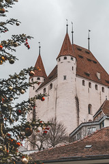 Schloss Thun Castle is a medieval castle in Thun. A city in the Bern Canton - Switzerland. Overcast winter day, Christmas tree in foreground