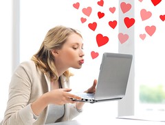 woman sending kisses with laptop computer